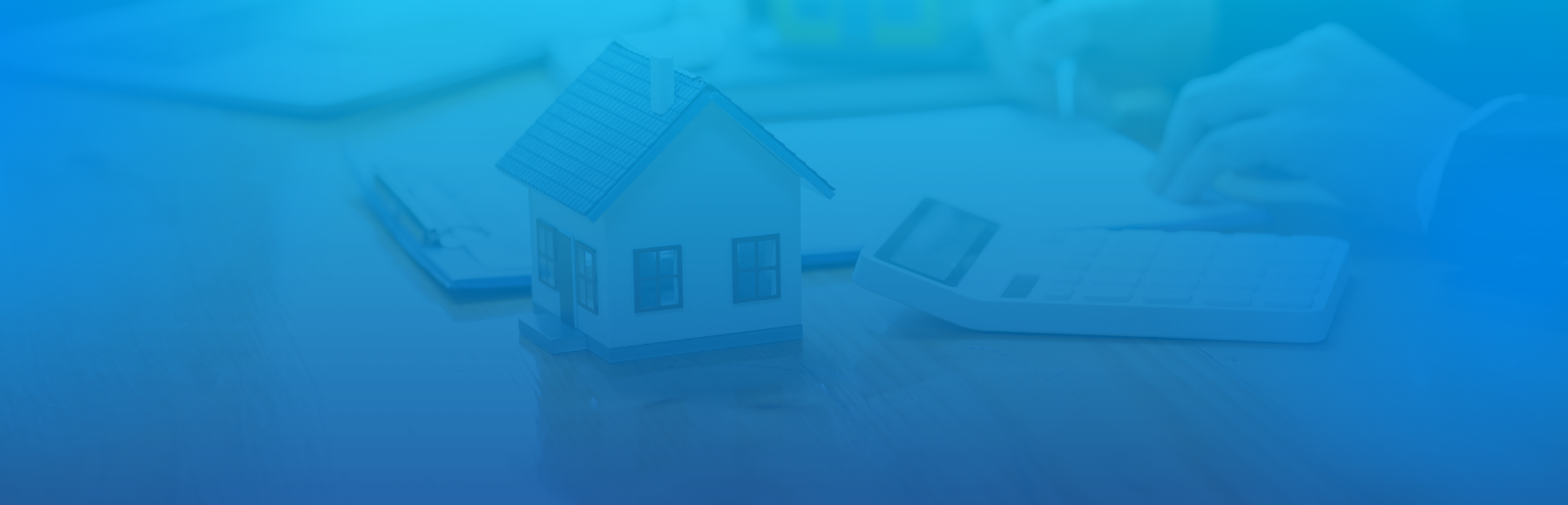 Image of a house with a calculator and mortgage documents in the process of being signed.