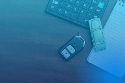 Chave de carro e miniatura de carro, com calculadora e bloco de notas, simbolizando crédito automóvel.
