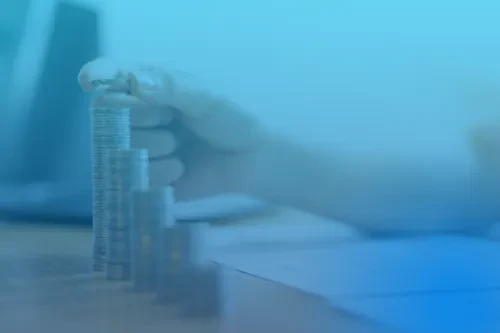 Alguém a juntar moedas em pilhas, com fundo azul