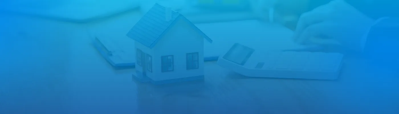 Imagem de uma casa com uma calculadora e documentos de crédito habitação em processo de assinatura.